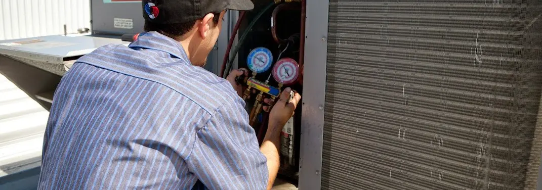 HVAC technician servicing a condenser unit in Chesapeake Ranch Estates