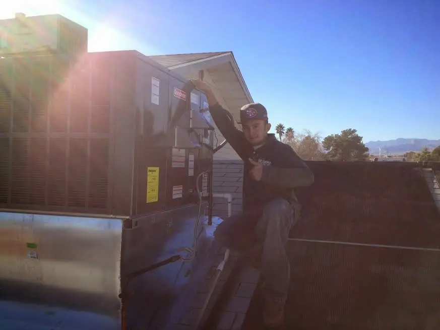 HVAC technician performing AC Tune-Up on a rooftop unit in Chesapeake Ranch Estates